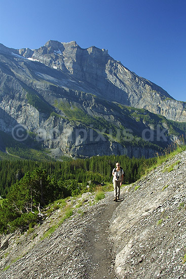 Bjergvandrer. Bjergvandrer p� vej op igennem Oeschinental p� vej mod Bl�mlisalph�tte; ; Kandersteg; Schweiz; Europa; ; bjergvandring, aktivferie, motion